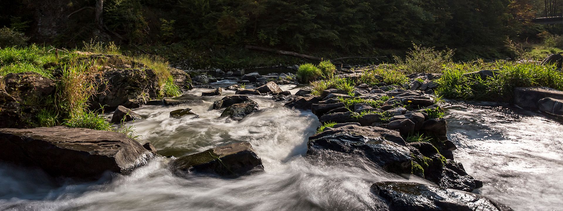 Quelle: iStock.com/Teka77 Dynamisches Bild eines rauschenden Wasserfalls bei Schladern.